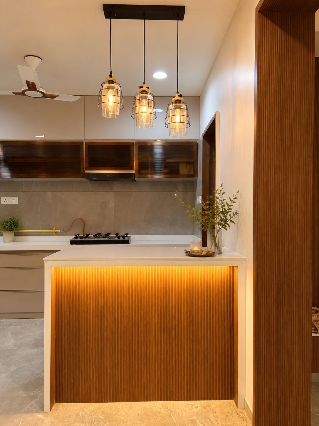 Kitchen island with pendant lighting at Begwani's Residence
